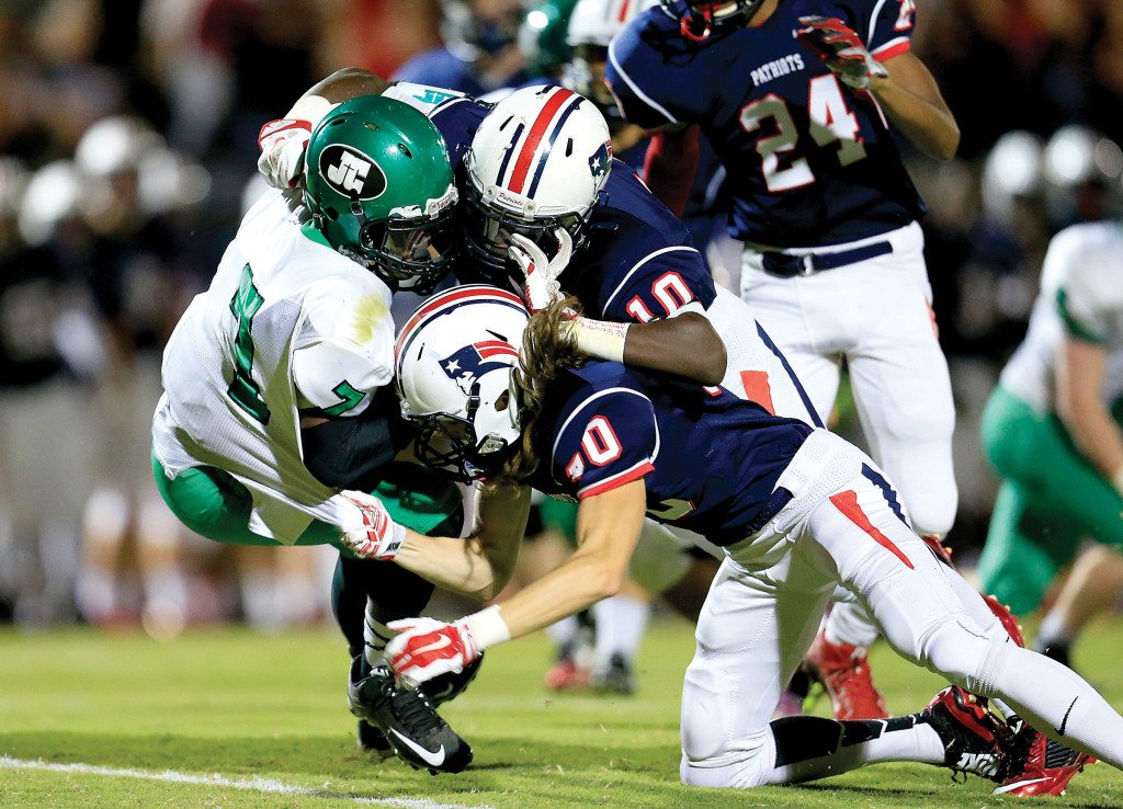 John Carroll’s Chris Burrell is hit by Homewood’s Aaron Phillips and Homewood’s Nick McCoy at Waldrop Stadium. Journal photo by Marvin Gentry