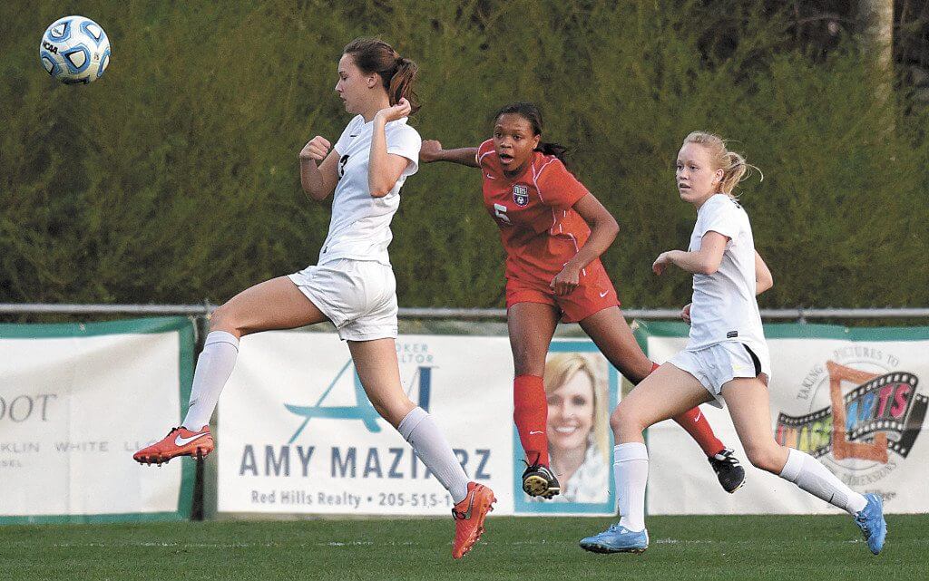 Vestavia Hills' Kennedy Hicks (right) makes a successful shot on goal past Mountain Brook's Lamar Campbell at Mountain Brook High School March 15. Photo by Mark Almond)