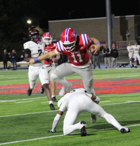 Rebels' quarterback Charlie Taaffe leaps over a Hoover defender.